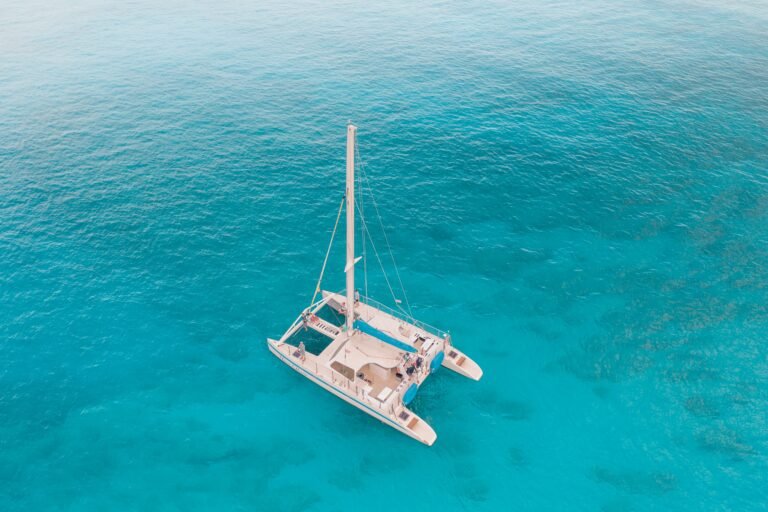Aerial view of a catamaran sailing in clear turquoise Ionian water