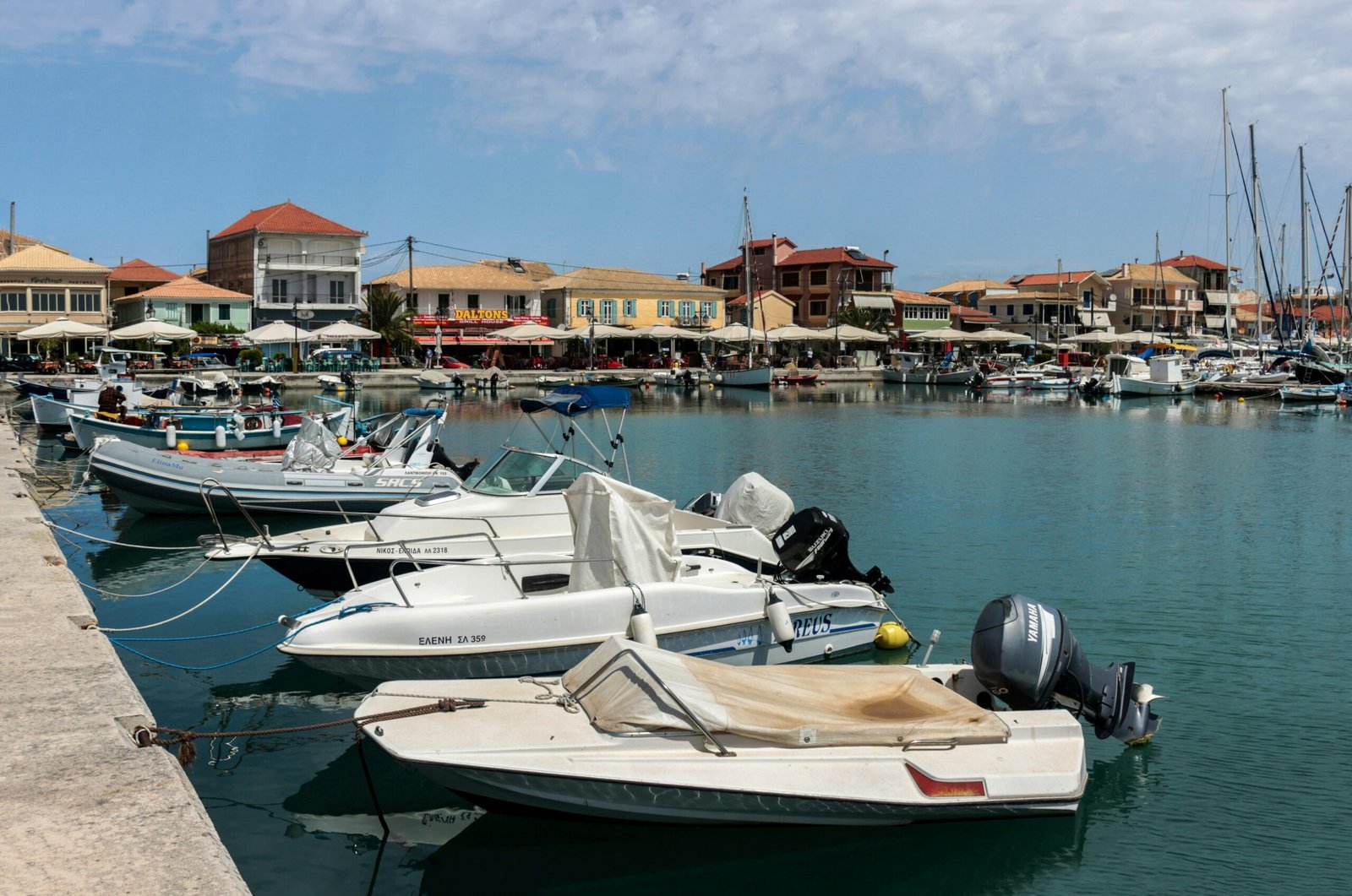 Small boats moored beside colourful waterfront buildings in Lefkada