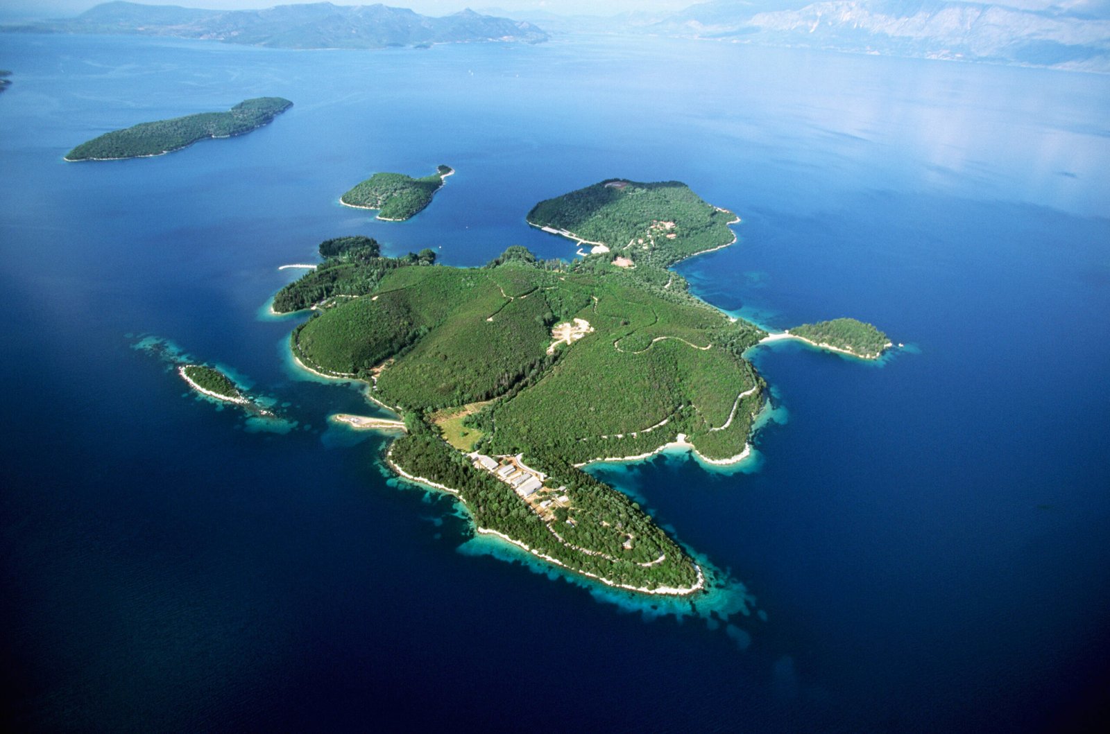 Aerial view of the forested Skorpios Island surrounded by the Ionian Sea